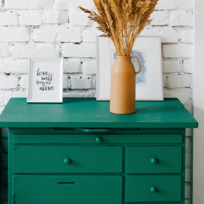 Refurbish green dresser with a flower pot and picture from on top.