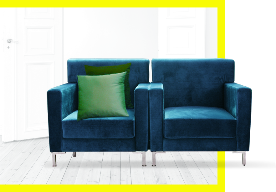 Two blue chairs with two green pillows on one of the chairs.